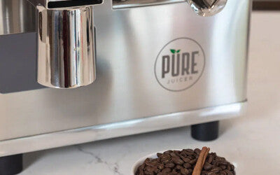 A PURE Juicer with a bowl of coffee beans and a cinnamon stick