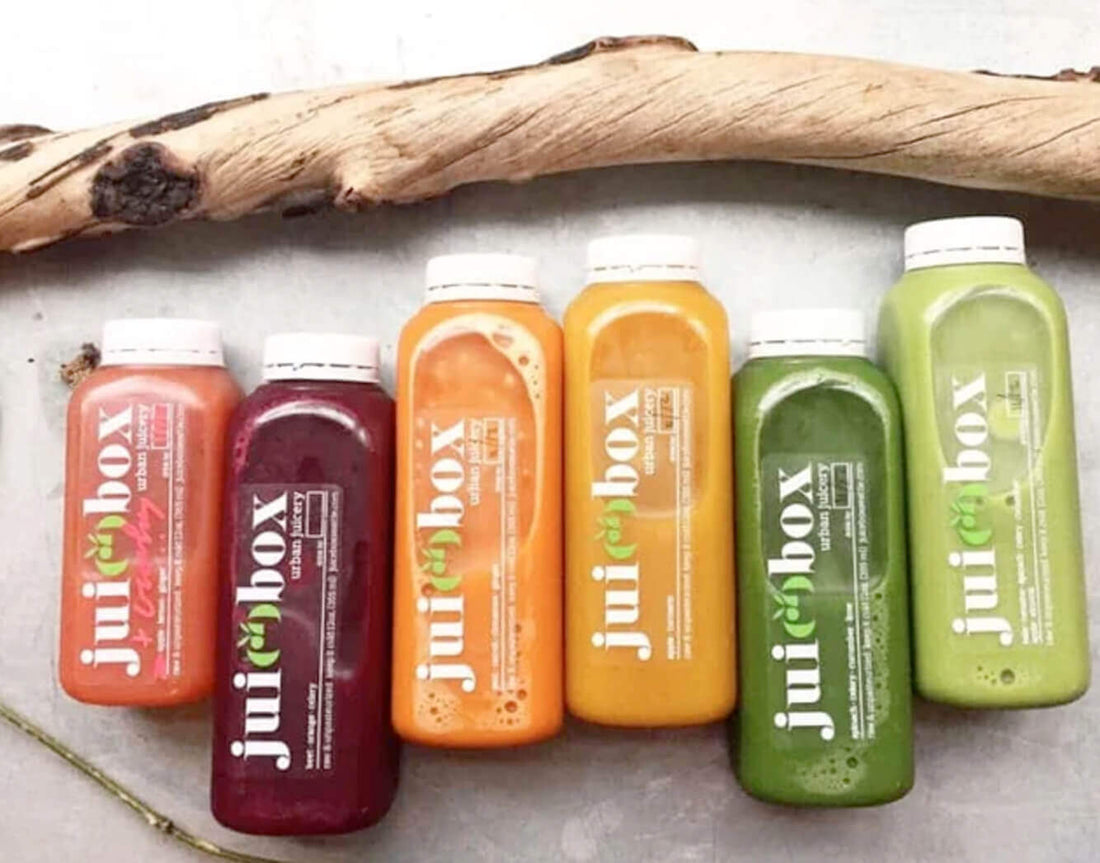 Row of Juicebox cold-pressed juice bottles in colors from red to green