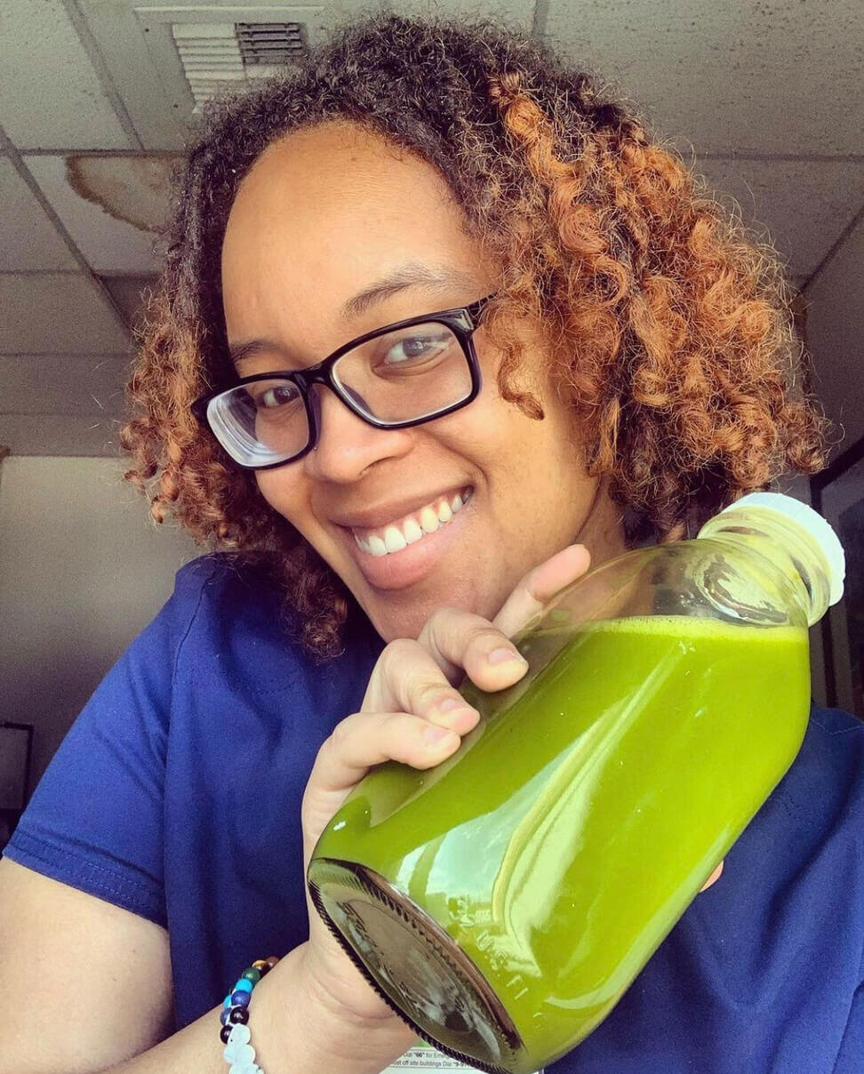 Kia Sanders holding a bottle of green juice