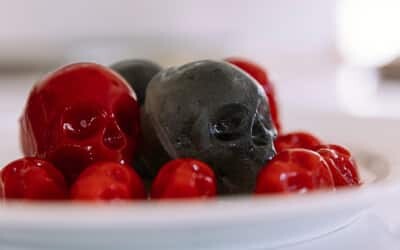 Red and black skull-shaped juice cubes on a white plate
