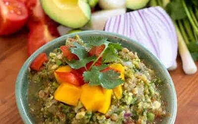 A bowl of fresh salsa topped with mango and cilantro