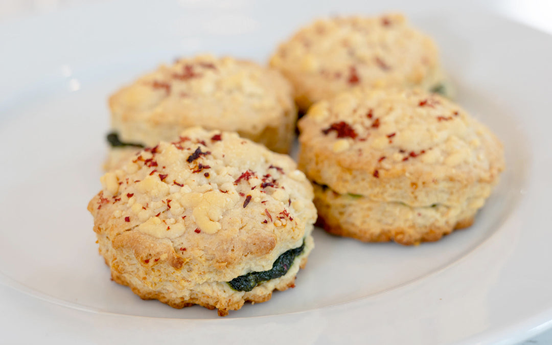 Four vegan olive oil biscuits topped with beet pulp on a white plate