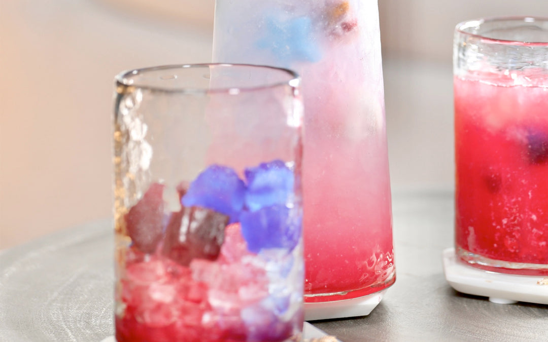 Glasses of red and blue iced drinks on a table